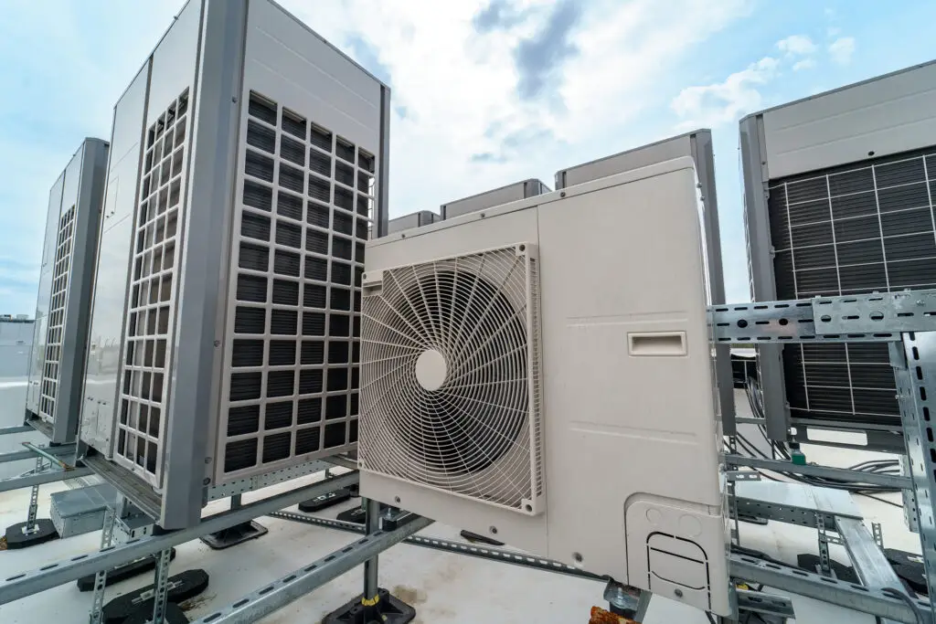 Valley Forge, PA Several large HVAC units are installed on a rooftop, arranged in a row on metal supports with a cloudy sky in the background—ideal for businesses seeking commercial air con repairs or an air conditioner repairing service near me.